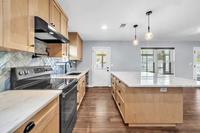 a kitchen with stainless steel appliances a sink stove and cabinets