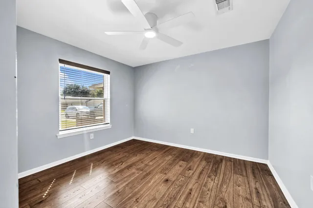 a view of an empty room with wooden floor