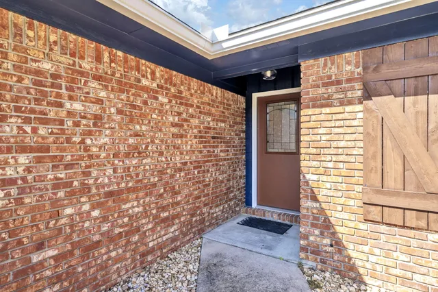 an empty room with wooden floor fireplace and windows
