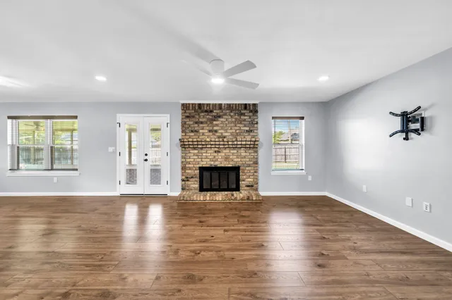 a large kitchen with a center island wooden floor and stainless steel appliances