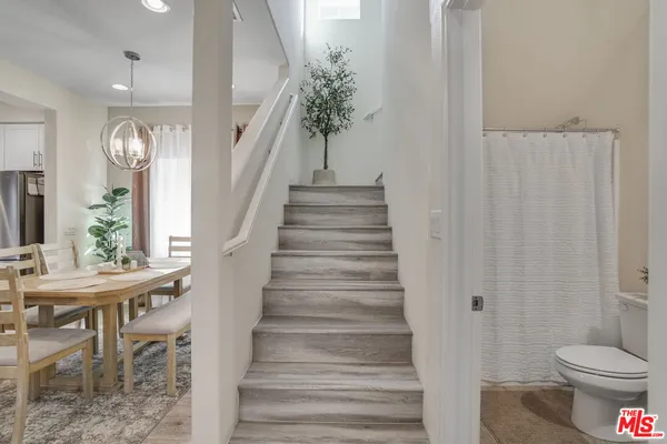 a view of a hallway with wooden floor and a dining room