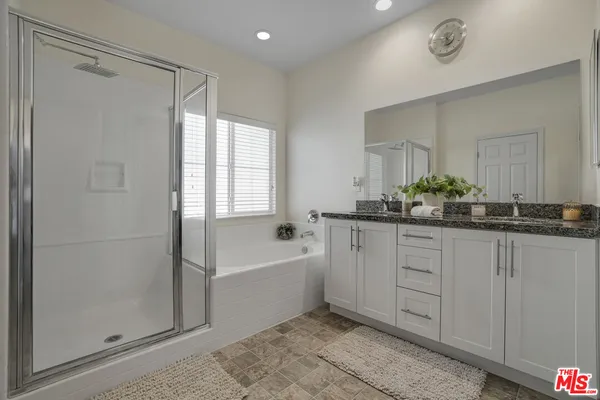 a bathroom with a double vanity sink a mirror and a bathtub