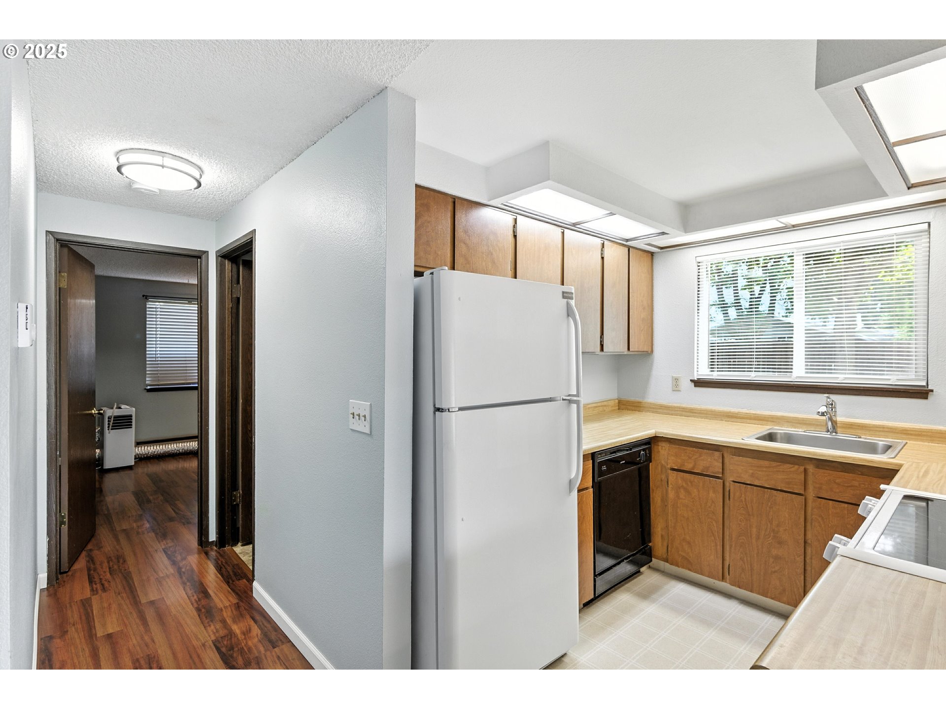3404 19th Avenue, Unit 117 Forest Grove, OR 97116 - Photo 11 of 18 a kitchen with a refrigerator a sink and dishwasher with wooden floor