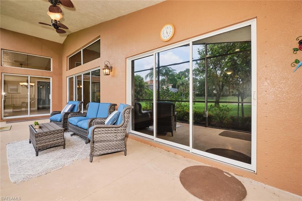 1415 Princess Sabal Point Naples, FL 34119 - Photo 24 of 42 Covered outdoor patio with a ceiling fan, vaulted ceiling, exterior wall lantern, and multiple sliding glass doors