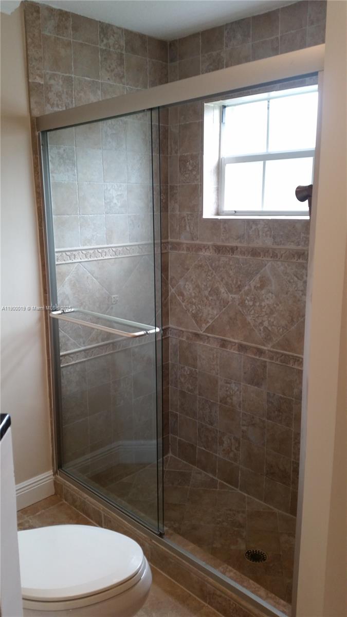 11071 Southwest 11th Place, Unit 124 Davie, FL 33324 - Photo 12 of 18 a bathroom with a toilet and a shower