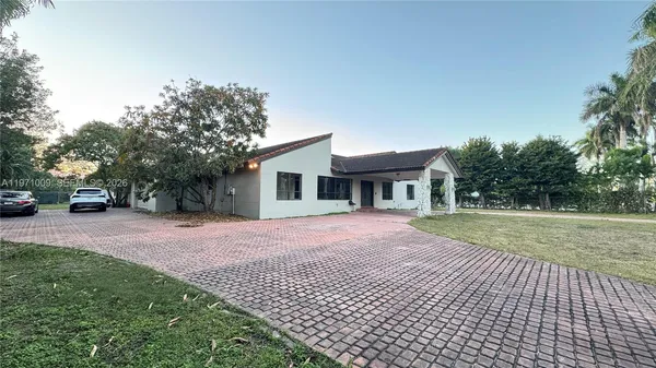 a front view of a house with a yard and trees