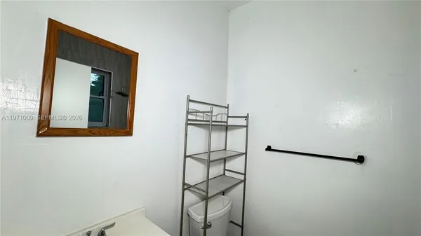 a bathroom with a granite countertop toilet sink and mirror