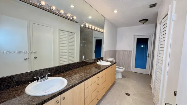 a bathroom with a sink and mirror with toilet