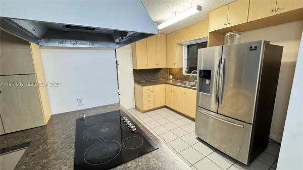 a kitchen with granite countertop a stove and a refrigerator