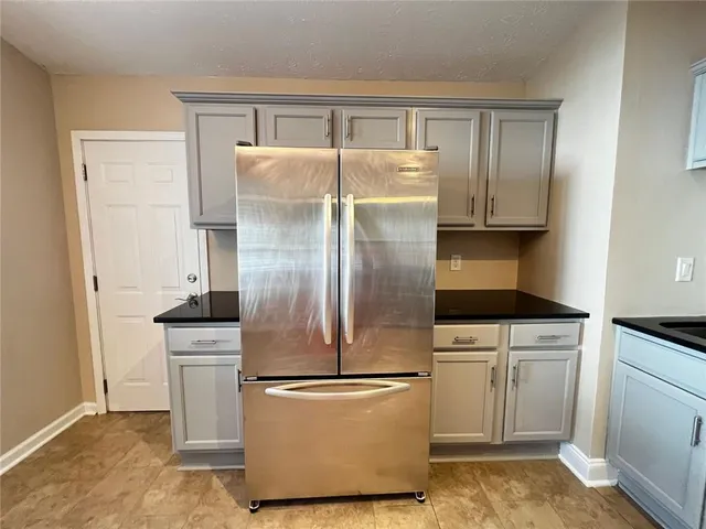 a kitchen with a refrigerator sink and cabinets
