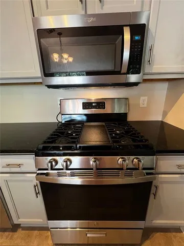 a stove top oven sitting inside of a kitchen
