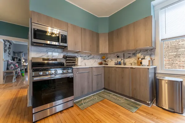 a kitchen with stainless steel appliances a stove a microwave and sink