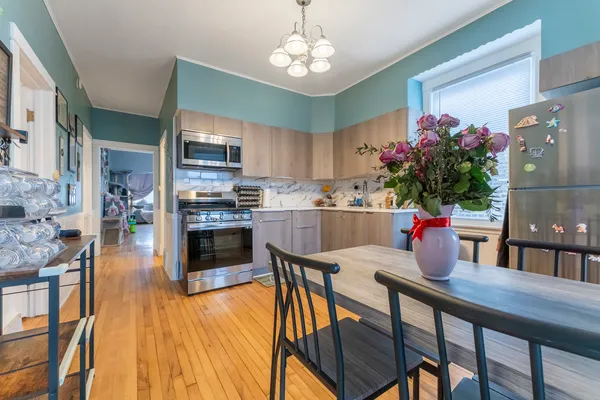 a kitchen with stainless steel appliances granite countertop a kitchen island hardwood floor and a sink