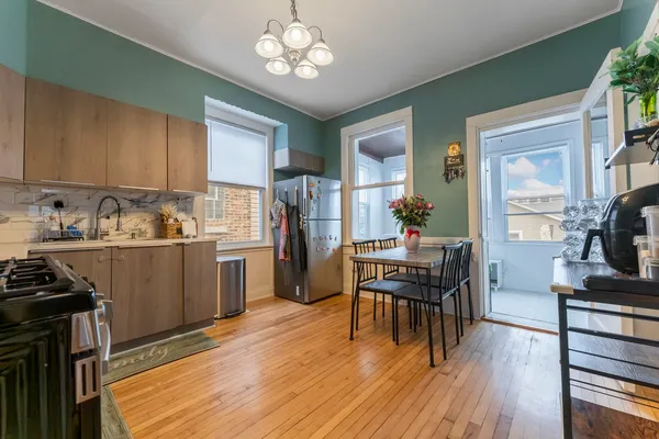 a kitchen with a table chairs refrigerator and cabinets