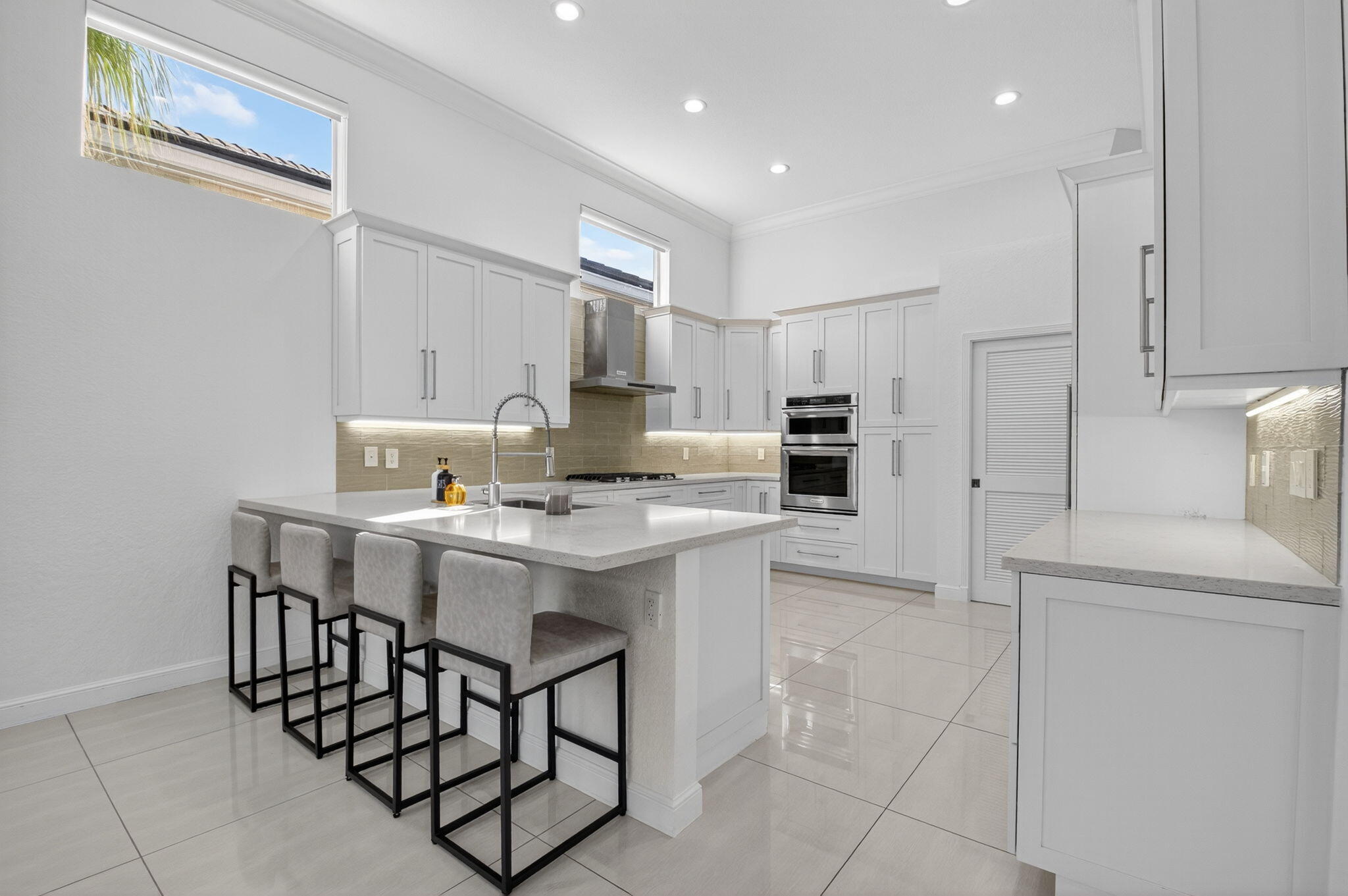 6270 Northwest 43rd Terrace Boca Raton, FL 33496 - Photo 11 of 27 a kitchen with stainless steel appliances a sink a stove a refrigerator cabinets and a dining table