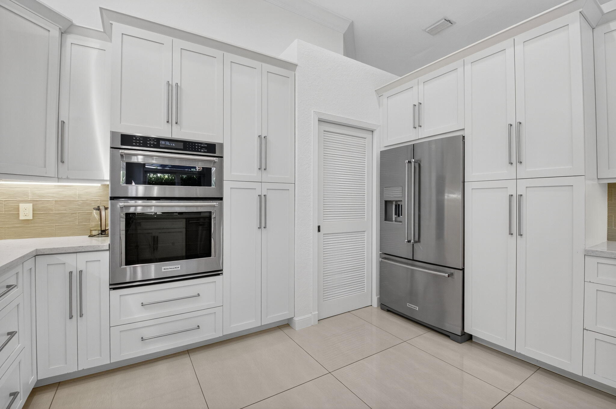 6270 Northwest 43rd Terrace Boca Raton, FL 33496 - Photo 15 of 27 a kitchen with white cabinets and stainless steel appliances