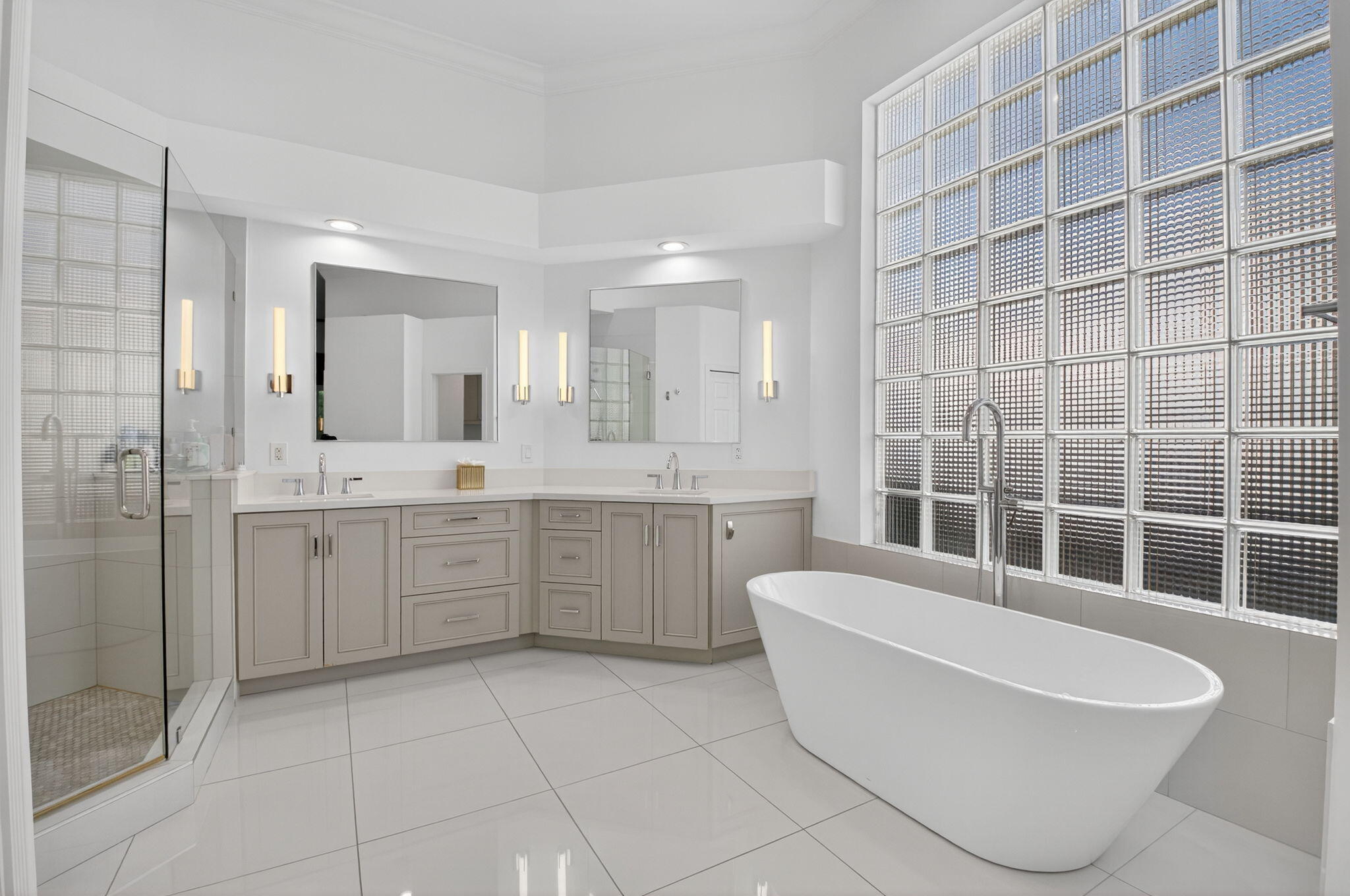 6270 Northwest 43rd Terrace Boca Raton, FL 33496 - Photo 18 of 27 a large bathroom with a double vanity sink a mirror and a bathtub