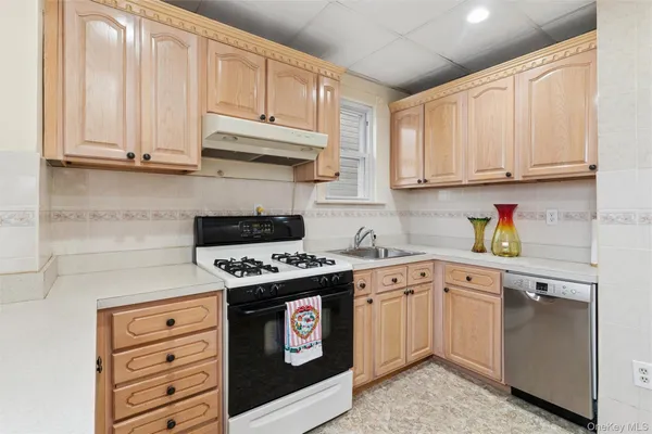 a kitchen with granite countertop white cabinets and stainless steel appliances