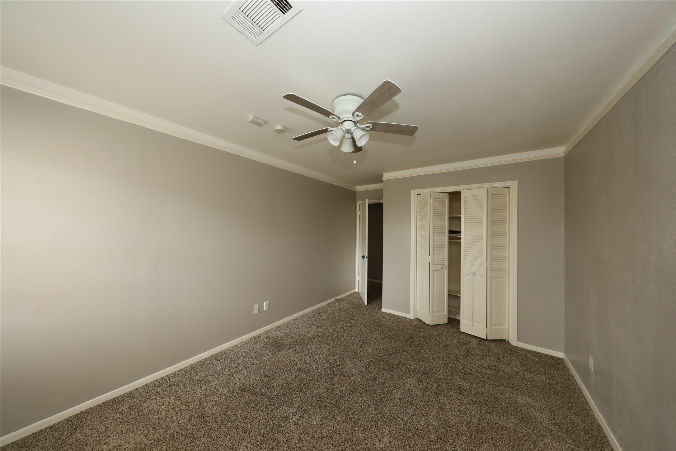 8519 Leader Street Houston, TX 77036 - Photo 13 of 27 an empty room with a ceiling fan and wooden floor