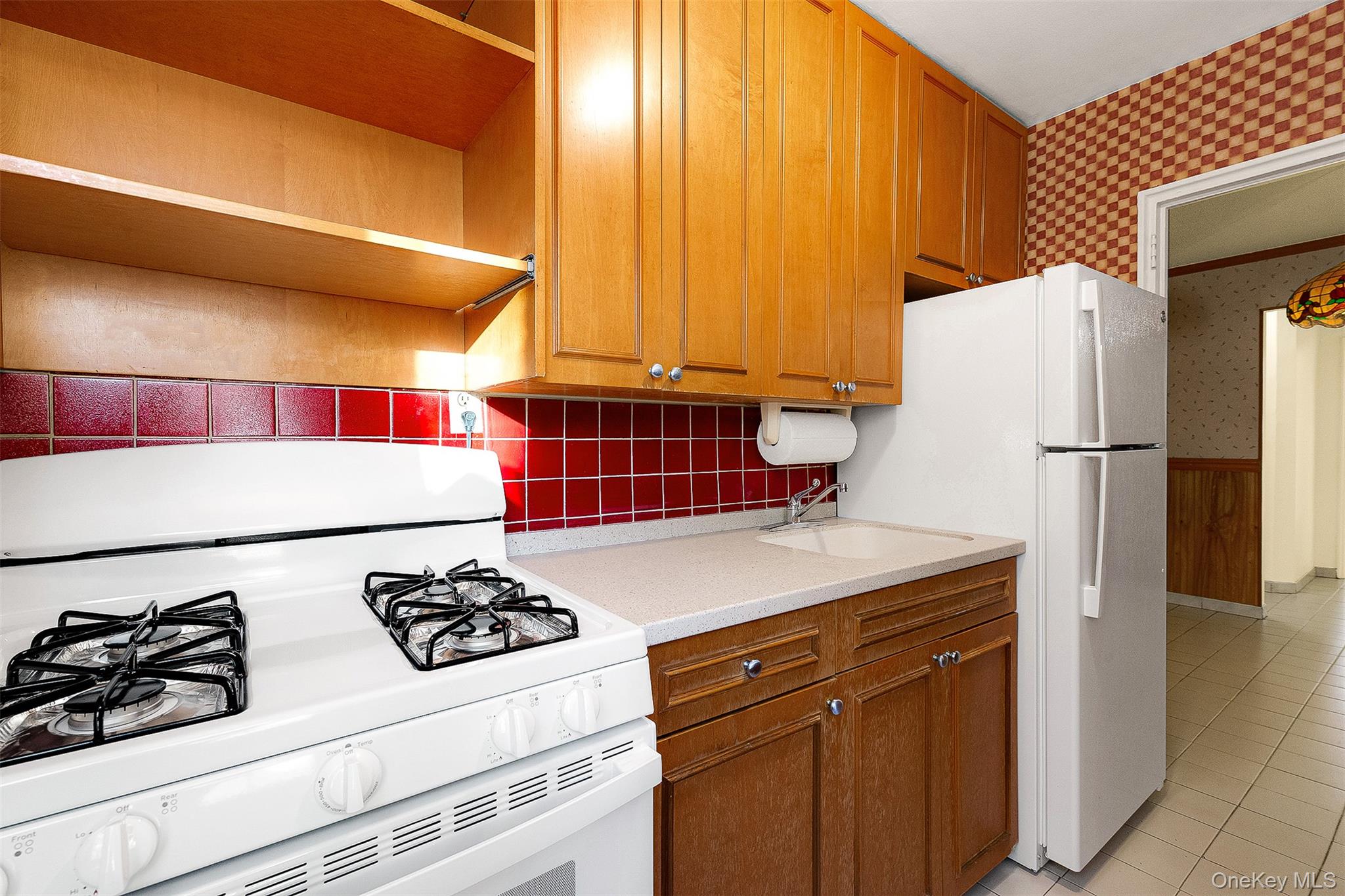 109-23 71st Road Queens, NY 11375 - Photo 12 of 21 a kitchen with a refrigerator and a stove