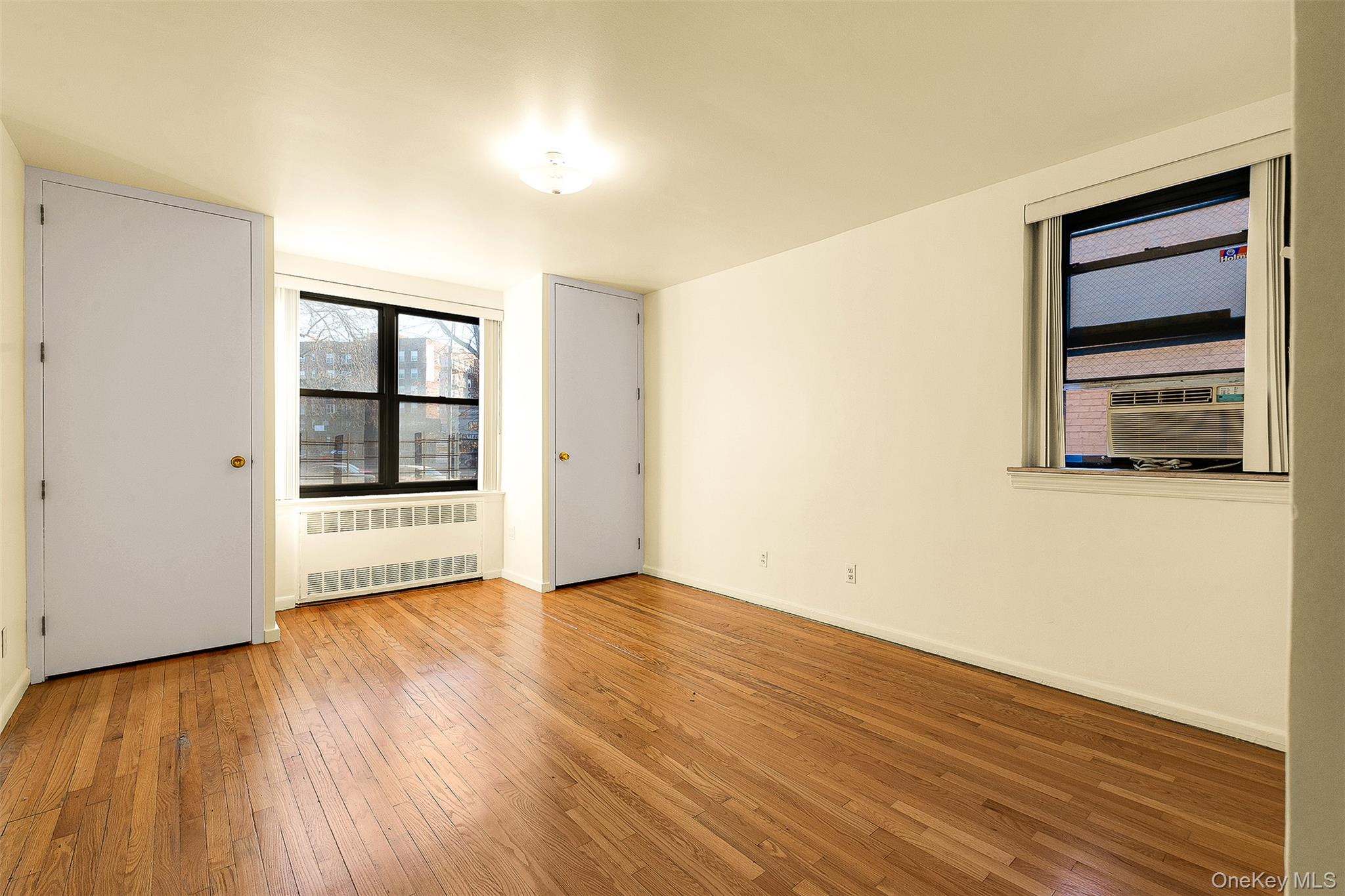 109-23 71st Road Queens, NY 11375 - Photo 17 of 21 a view of an empty room with wooden floor and a window