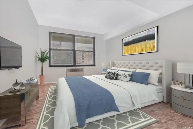 a bedroom with bed and a flat tv screen on dresser