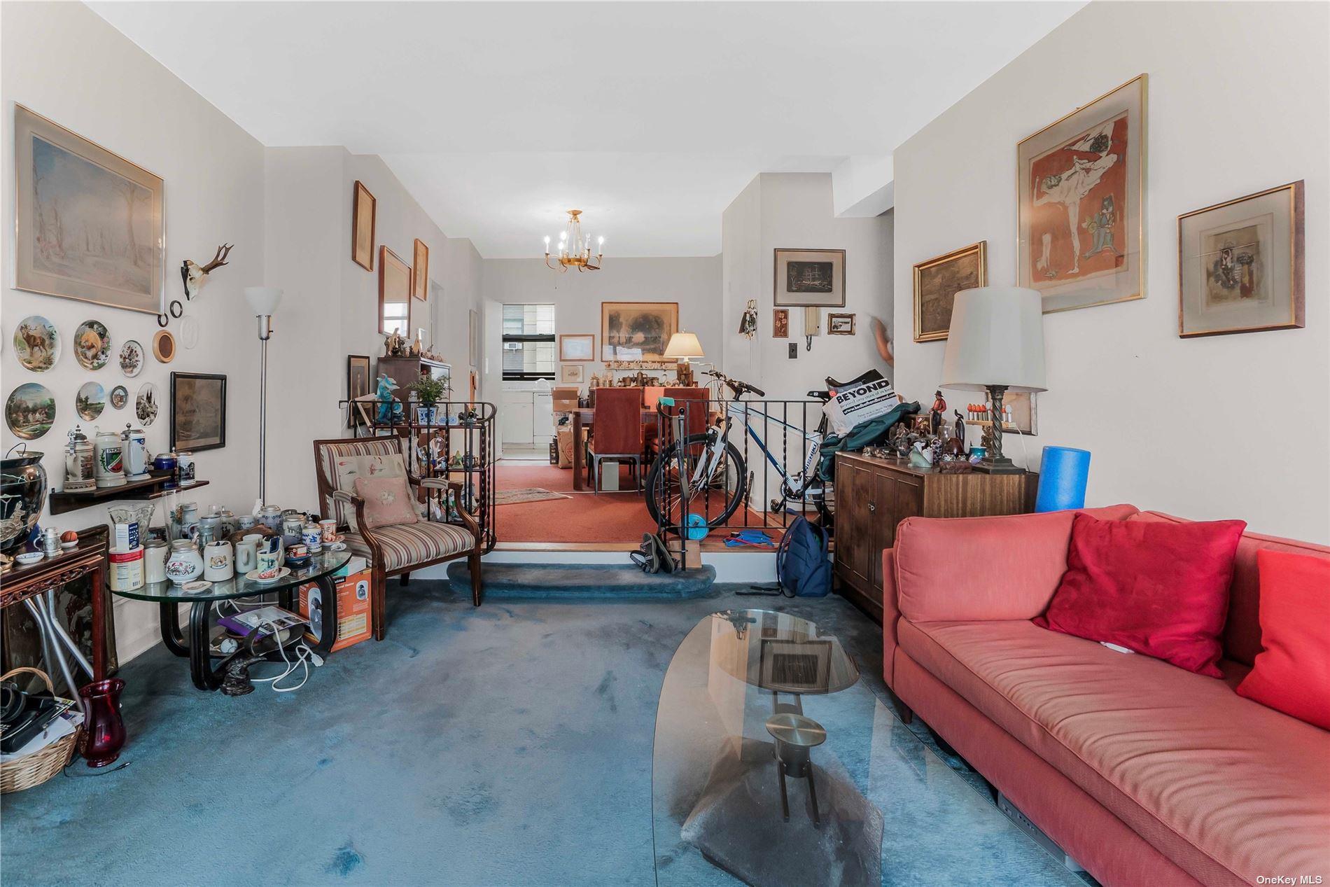 98-22 63rd Drive, Unit 5E Queens, NY 11374 - Photo 6 of 15 a living room with furniture and a flat screen tv