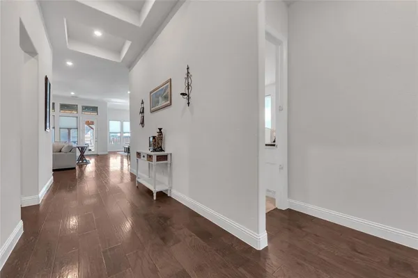 a view of a hallway with wooden floor and a living room
