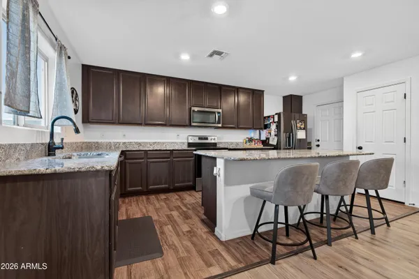 a living room with furniture kitchen view and a window