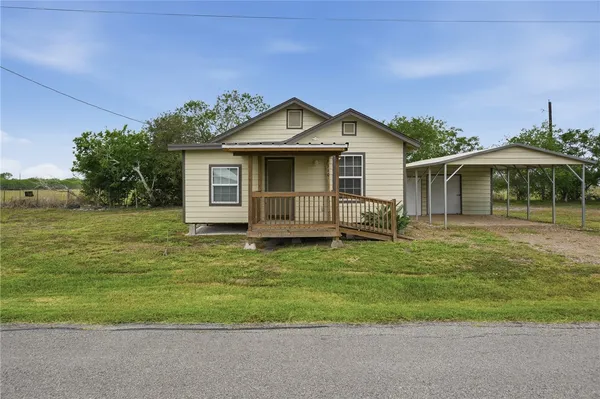 a front view of a house with a garden