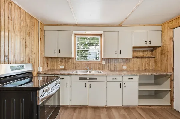 a kitchen with a sink window and cabinets