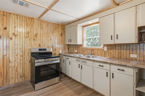 a kitchen with cabinets appliances and a window