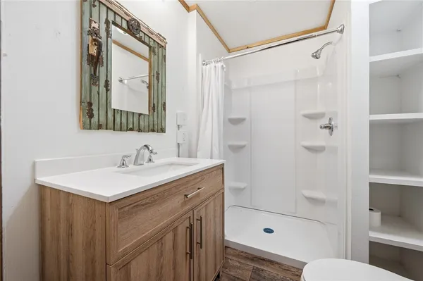 a bathroom with a sink a toilet and shower