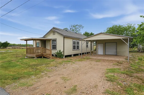 a front view of a house with a garden and porch
