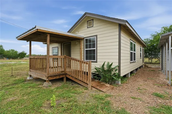 a view of a house with a yard and sitting area
