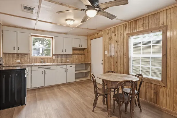 a kitchen with granite countertop a sink appliances cabinets and wooden floor