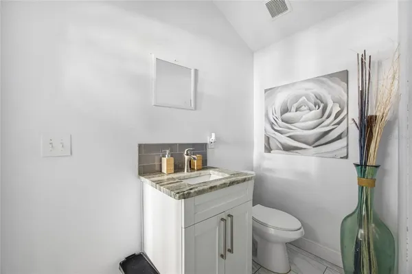 a bathroom with a granite countertop toilet and a sink