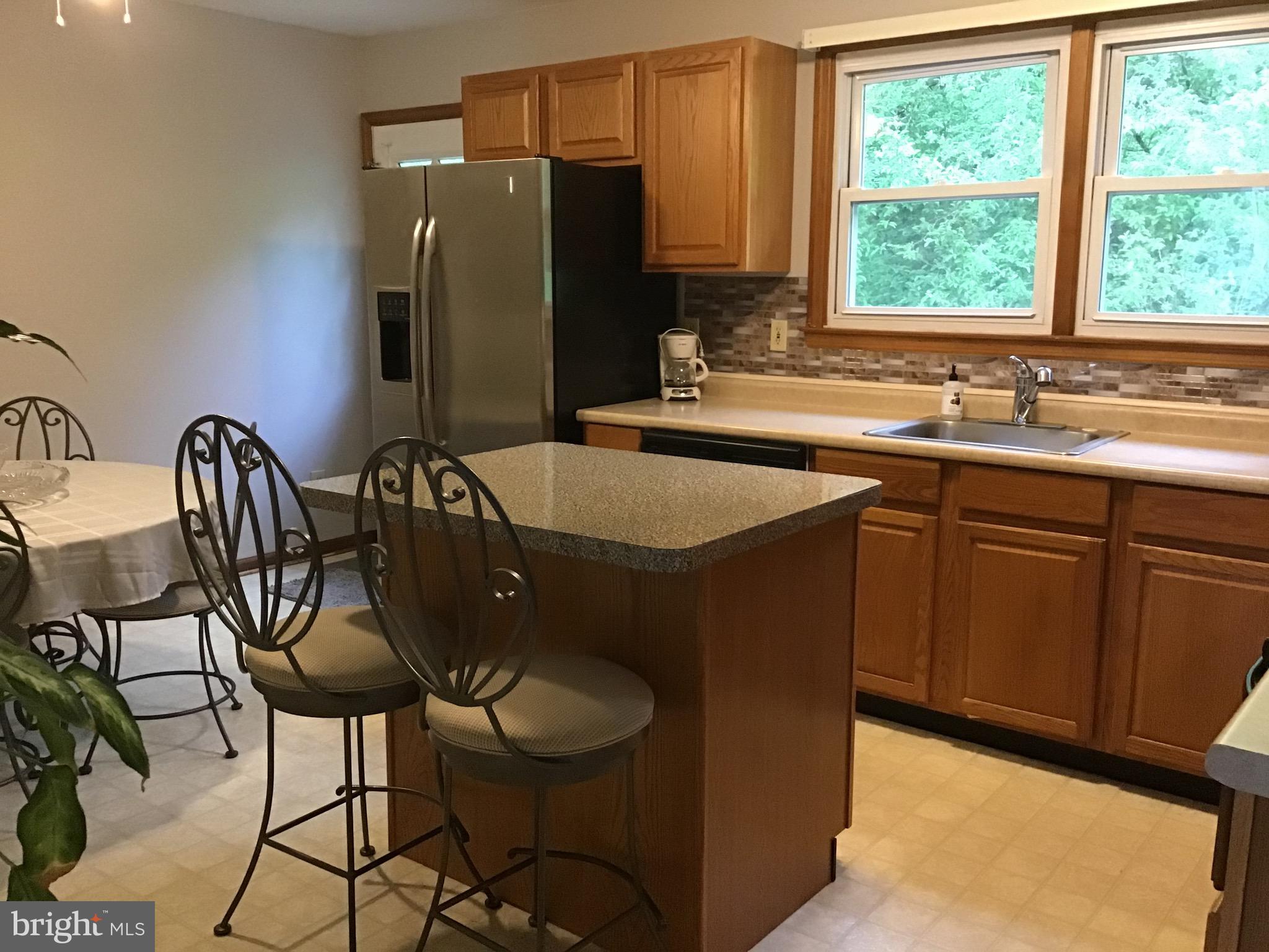 1503 Marshall Mill Road Franklinville, NJ 08322 - Photo 6 of 34 a kitchen with stainless steel appliances granite countertop a sink a window and chairs