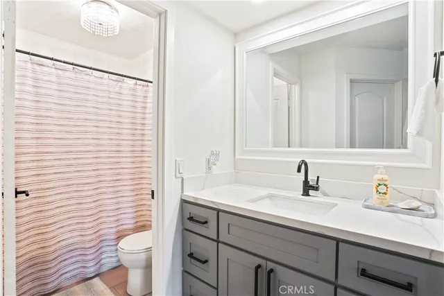 a bathroom with a sink a toilet a mirror and shower