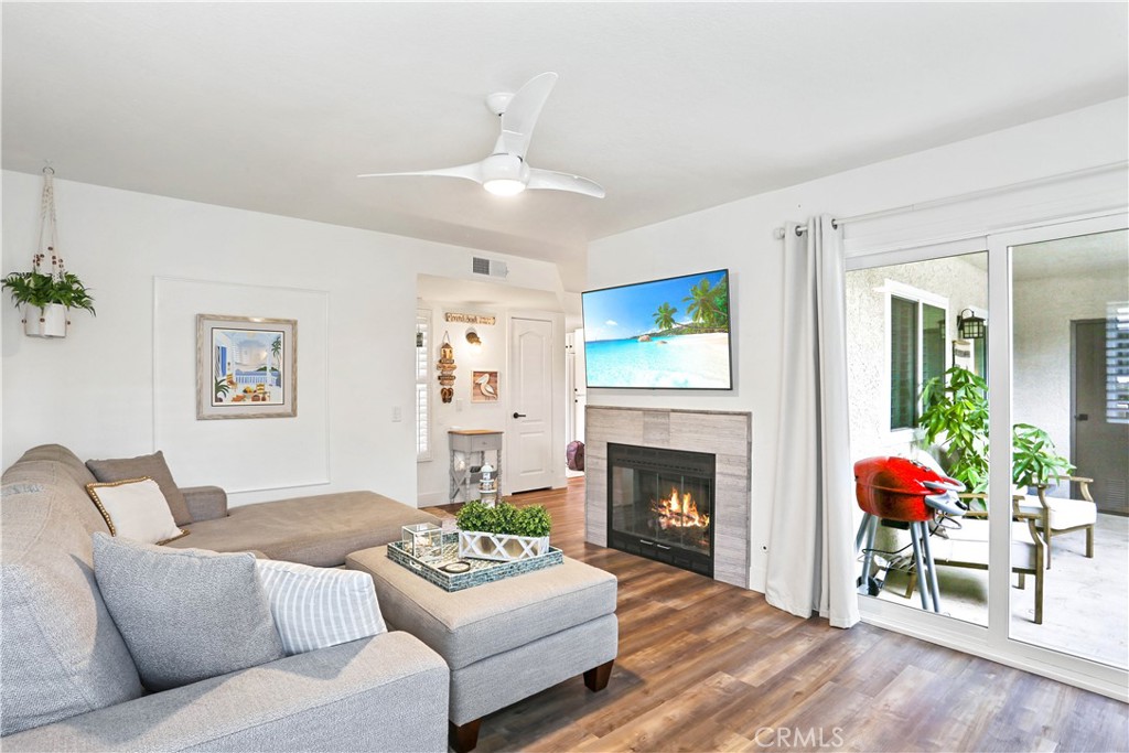 12 Corniche Drive, Unit A Dana Point, CA 92629 - Photo 4 of 26 a living room with furniture a fireplace and a dining table with wooden floor