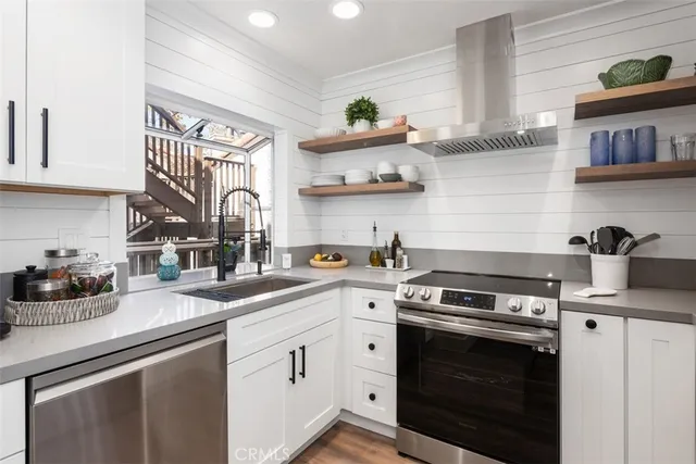 a kitchen with cabinets stainless steel appliances and a sink