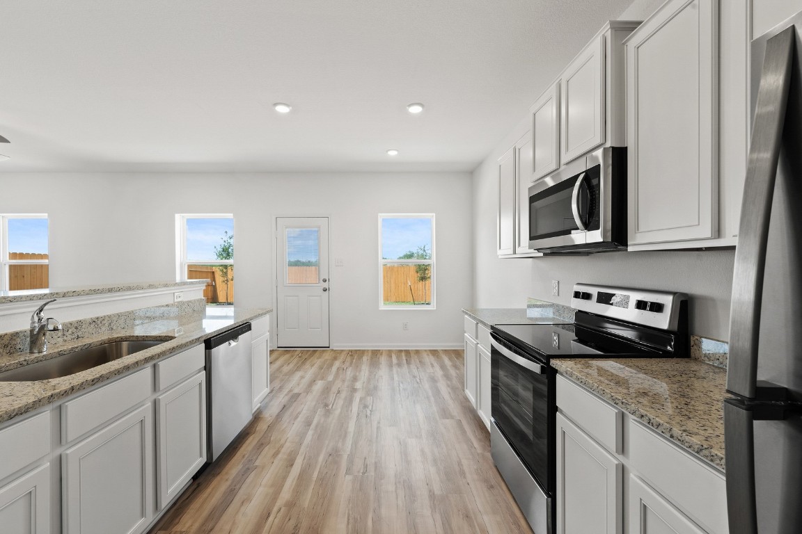 a kitchen with stainless steel appliances granite countertop a sink and stove top oven