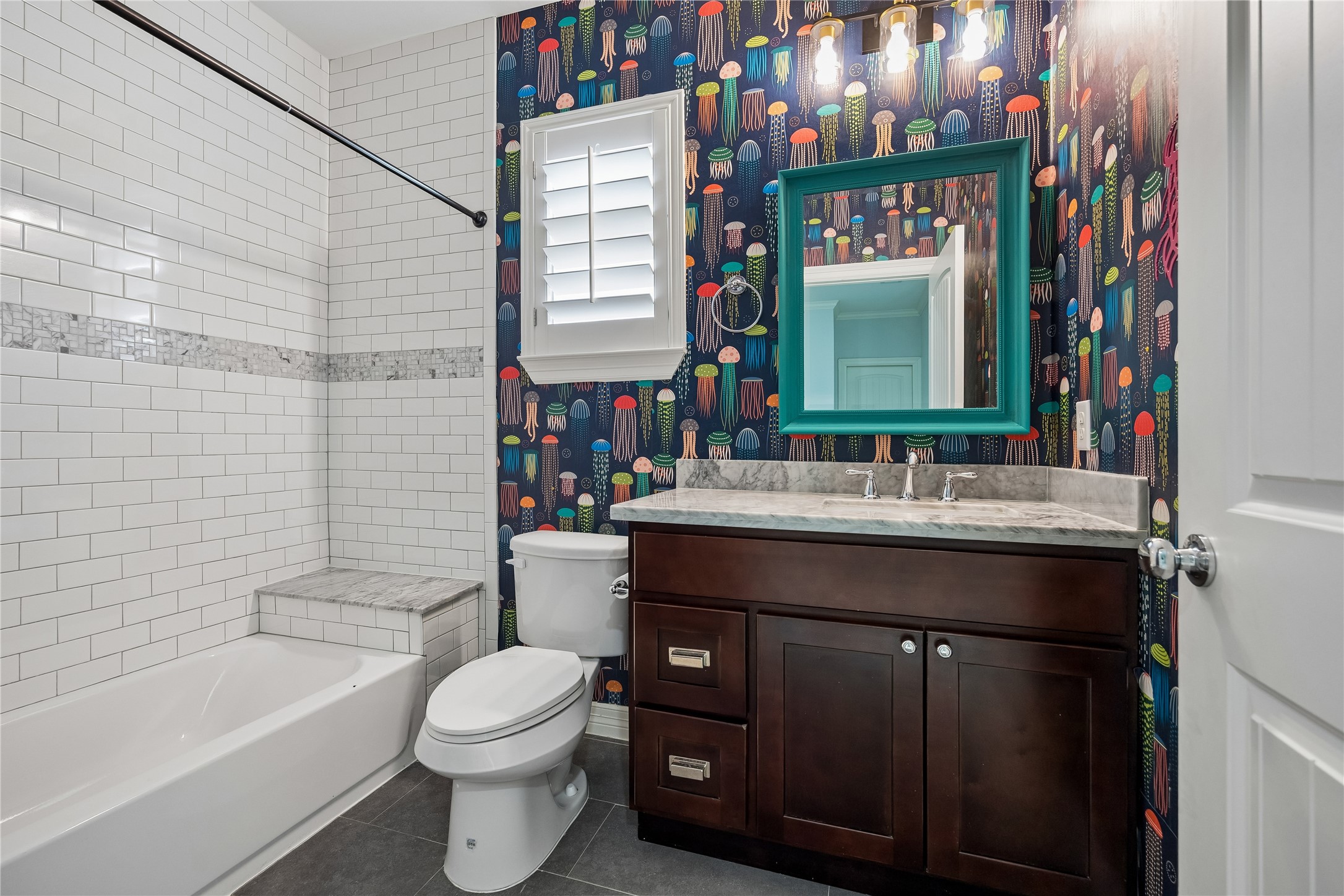 5121 Libbey Drive Houston, TX 77092 - Photo 15 of 24 Shared guest bath with adorable wallpaper and tub/shower with convenient bench.