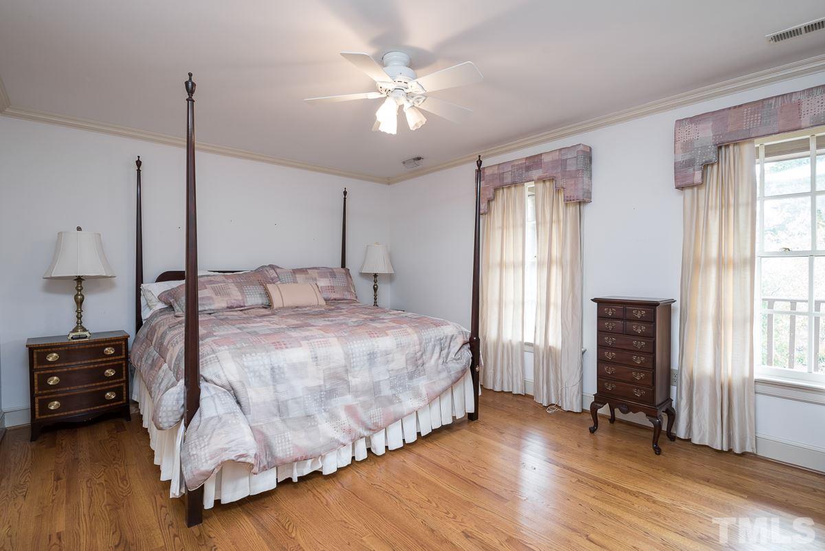 3302 Ridgecrest Court Raleigh, NC 27607 - Photo 12 of 23 a bedroom with a bed and a chandelier