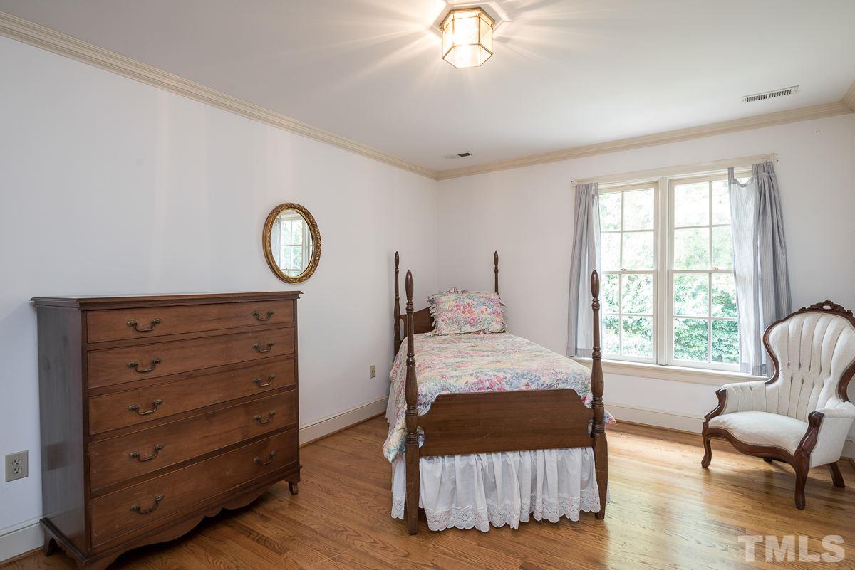 3302 Ridgecrest Court Raleigh, NC 27607 - Photo 15 of 23 a bedroom with a bed and a chair