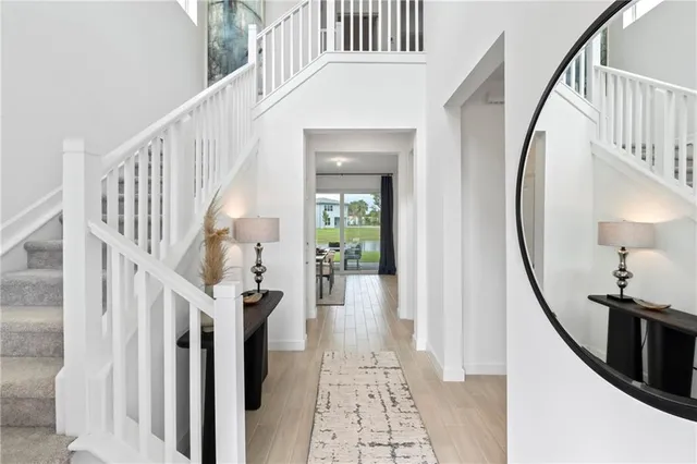 a view of staircase with lots of frames on wall and a chandelier