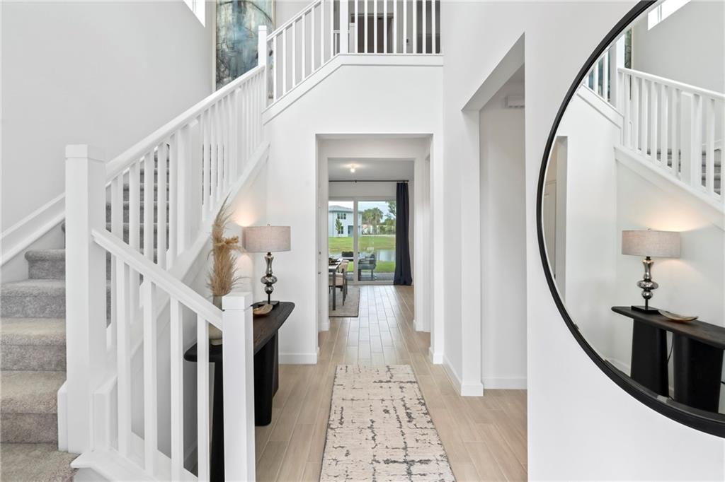 22036 Brookmont Drive Boca Raton, FL 33433 - Photo 3 of 32 a view of staircase with lots of frames on wall and a chandelier
