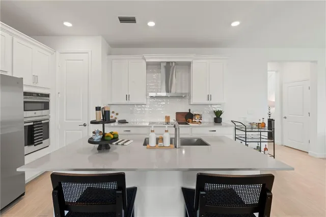 a kitchen with a sink a stove and chairs