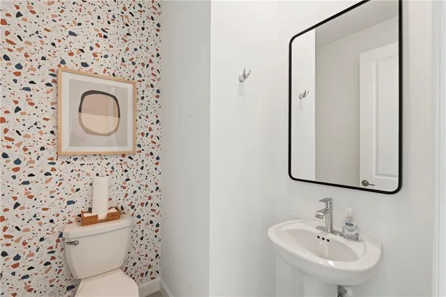 a bathroom with a toilet sink and mirror