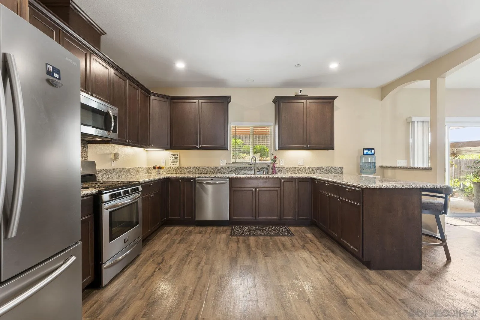 1637 Paraiso Avenue Spring Valley, CA 91977 - Photo 3 of 45 a kitchen with stainless steel appliances kitchen island granite countertop a sink refrigerator and microwave